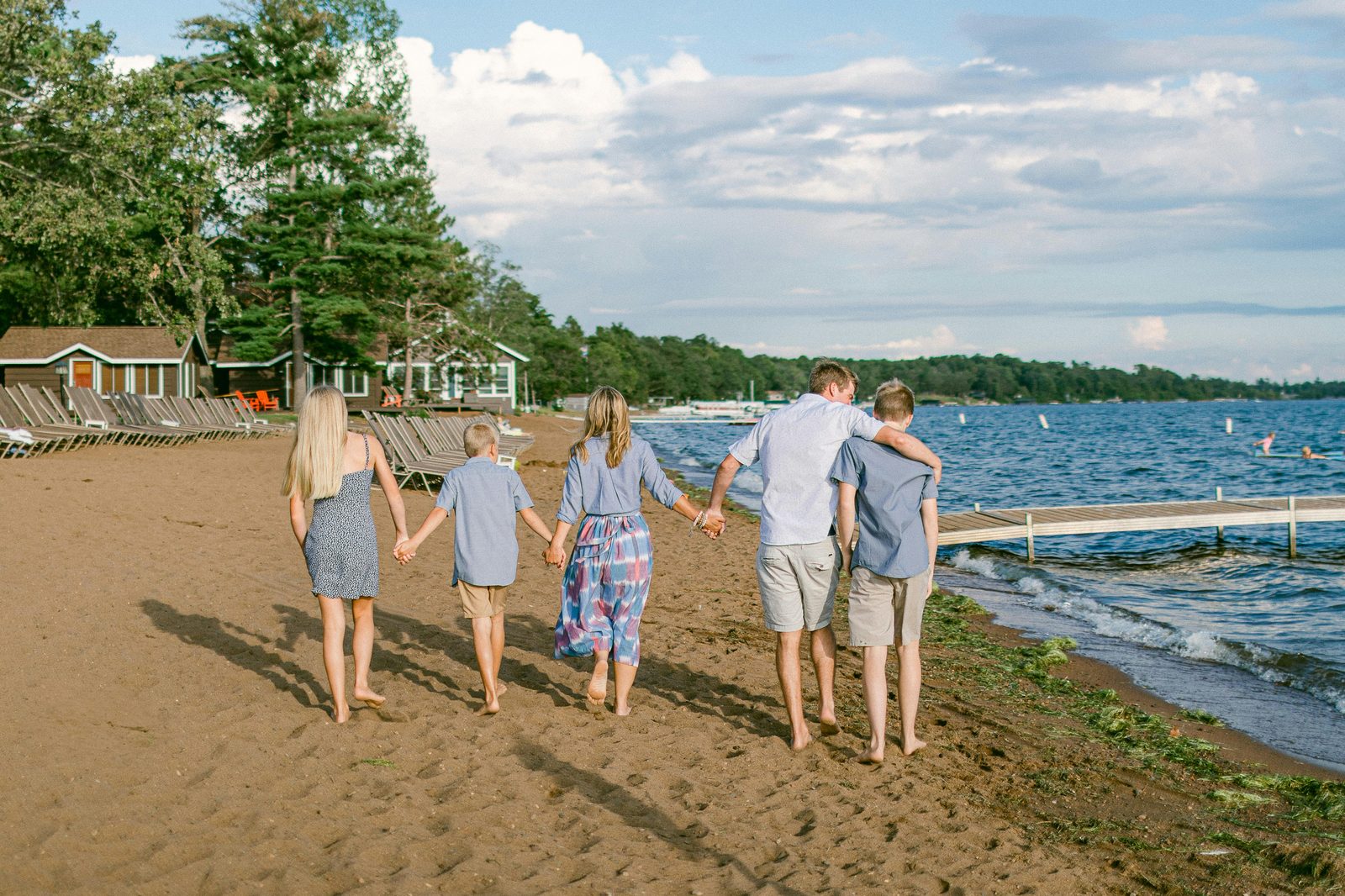 A family walking together holding hands at sunset